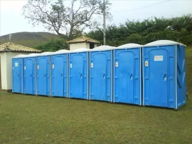 Fileira de banheiros químicos instalados em gramado para evento